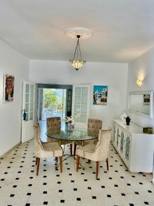 a dining room with a glass table and chairs at Villa Mer in Nabeul