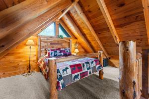 a bedroom with a bed in a log cabin at Cozy Mountain Cabin Getaway with Hot Tub for 4 Guests in Pigeon Forge