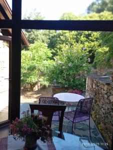 a patio with a table and two chairs and a window at Casa da Vita in Ferreira