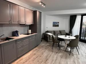 eine Küche und ein Wohnzimmer mit einem Tisch und einer Couch in der Unterkunft Twin Waves in Costinești