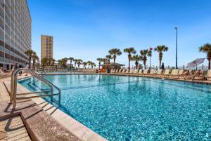 a swimming pool in a resort with palm trees at 1BR Sleeps 5 at The Summit with Ocean Front Views in Panama City Beach