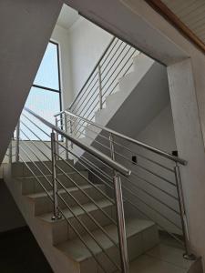 a staircase with metal railing in a building with a window at Lido System Makonde Village in Thohoyandou
