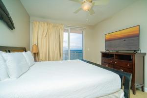 a bedroom with a bed and a flat screen tv at Beachfront Haven 2 BDR Kid-Friendly Resort in Panama City Beach