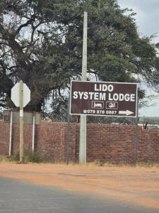 a sign for a lido system lodge on the side of a road at Lido System Makonde Village in Thohoyandou