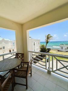 einen Balkon mit einem Tisch und Stühlen sowie Strandblick in der Unterkunft Ocean Bliss Apt 3-Quiet Retreat with Ocean View in Christchurch
