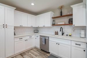 Una cocina blanca con gabinetes blancos y un fregadero. en Spacious 4BD with Pool and Putting Green Near Old Town Scottsdale, en Scottsdale