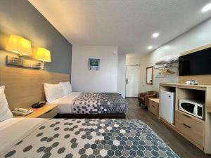 a hotel room with a bed and a tv at Econo Lodge Motel Village in Calgary