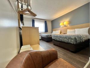 a hotel room with two beds and a couch at Econo Lodge Motel Village in Calgary