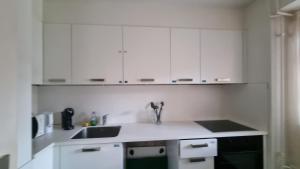a kitchen with white cabinets and a sink at Sin City Luzern in Luzern