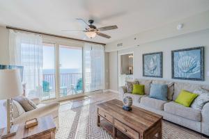 a living room with a couch and a table at Sunset Shores - Oceanfront Condo Bliss in Panama City Beach