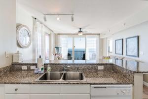 a kitchen with a sink and a large mirror at Sunset Shores - Oceanfront Condo Bliss in Panama City Beach +15 photos