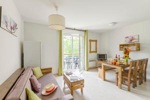 a living room with a couch and a table at Lagrange Vacances Les Terrasses du Lac in Aureilhan