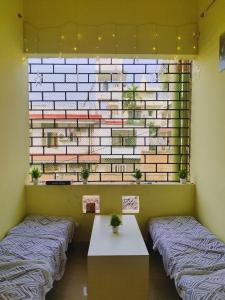 two beds in a room with a brick wall at Nomad's Nest Backpackers Hostel in Guwahati