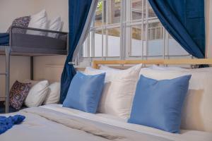 a bedroom with a bed with blue and white pillows at Condado Home - Private Back yard by PH in San Juan