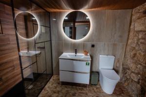 a bathroom with a sink and a toilet and a mirror at Open Space com Jacuzzi a 5 mn do centro de Lamego in Lamego +23 photos