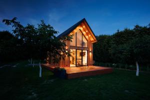 a small house with lights on it in a field at Wyspa Roztocze in Kulików +15 photos