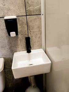 a white sink in a bathroom next to a toilet at Dalia Room, Paseo Durango in Durango