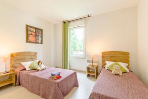 En eller flere senge i et værelse på Lagrange Vacances Les Terrasses du Lac