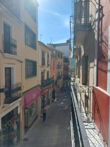an alley with buildings and people walking down a street at Apartamentos Plasencia Bambu in Plasencia
