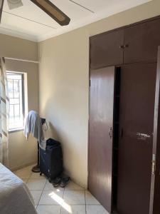 a bedroom with a bed and a door and a window at Epizone in Mokopane