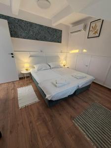 a bedroom with a large bed and a wooden floor at White House Apartments - Forest in Haskovo