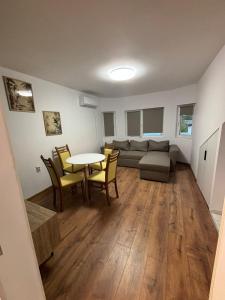 Una sala de estar con un sofá, una mesa y sillas. en White House Apartments - Forest, en Haskovo