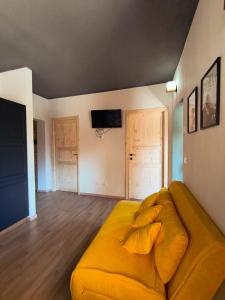 a living room with a yellow couch in a room at Villa Rosina in Saint Vincent +6 photos