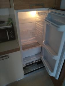 an empty refrigerator with its door open in a kitchen at Oasis Beach Lozenets 1 bed in Lozenets