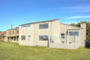 a house with large windows on a grass field at Neel Nirvana - Deck With BBQ & Community Pool in Sea Ranch
