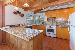 a large kitchen with wooden cabinets and white appliances at Seaclusion - Close to Trails - Hot Tub in Sea Ranch