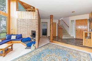 a living room with a blue couch and a staircase at Seaclusion - Close to Trails - Hot Tub in Sea Ranch +15 photos
