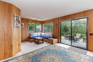 a living room with wooden walls and a large window at Seaclusion - Close to Trails - Hot Tub in Sea Ranch