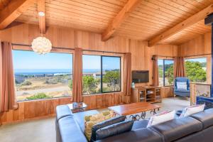 a living room with a couch and a table at Sea Meadow - Panoramic Ocean View in Sea Ranch
