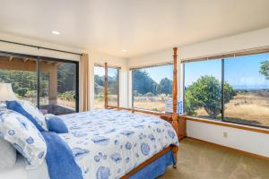 a bedroom with a bed and large windows at Sea Meadow - Panoramic Ocean View in Sea Ranch