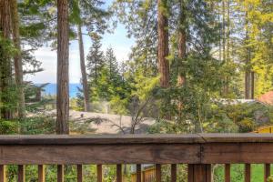 a wooden deck with a view of a beach and trees at Searenity by the Sea - Private Hot Tub in Gualala +29 photos