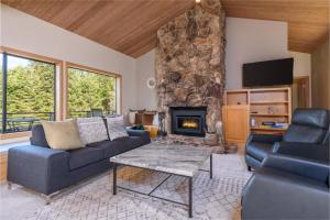a living room with a couch and a fireplace at Riverview - Private Hot Tub - Sleeps 12 in Sea Ranch