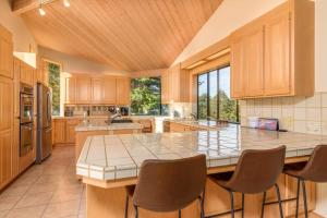 a large kitchen with a large island with chairs at Riverview - Private Hot Tub - Sleeps 12 in Sea Ranch +41 photos
