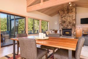 a dining room with a table and a fireplace at Riverview - Private Hot Tub - Sleeps 12 in Sea Ranch
