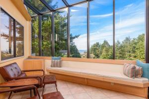 a room with a bench in front of windows at Riverview - Private Hot Tub - Sleeps 12 in Sea Ranch