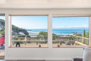 a room with two windows looking out at the ocean at Ocean Bungalow - Tesla EV Station & Near Trails in Gualala