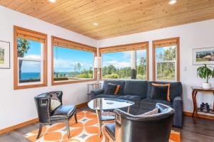 a living room with a couch and chairs and windows at Quaint Cottage for 2 With Ocean Views in Gualala