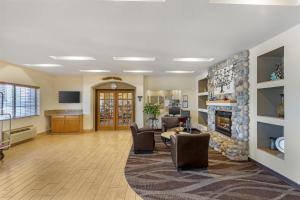 a living room with a fireplace and a table and chairs at Best Western Firestone Inn & Suites in Longmont