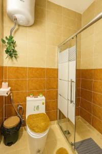 een badkamer met een toilet en een glazen douche bij Beit Ahlam Quiet Duplex Villa with Terrace and Scenic View near Umm Qais Ruins in Um Qeis