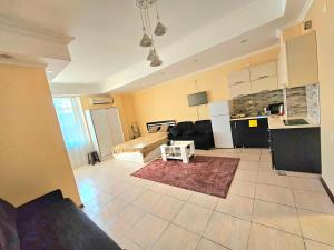 a large living room with a couch and a kitchen at apartment Leyla in Batumi