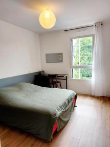ヴァンヌにあるPetite dépendance terrasse proche centreのベッドルーム1室(ベッド1台、窓、デスク付)