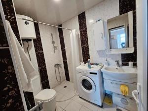 a bathroom with a washing machine and a sink at apartment Leyla in Batumi