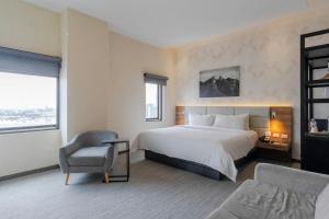a hotel room with a bed and a chair at SJ Grand Hotel Monterrey in Monterrey +25 photos