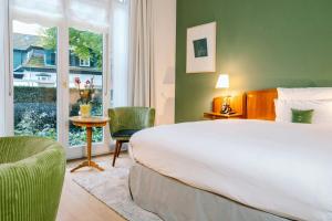 a bedroom with a bed and a table and a window at Louis C Jacob, Hamburg, Autograph Collection in Hamburg