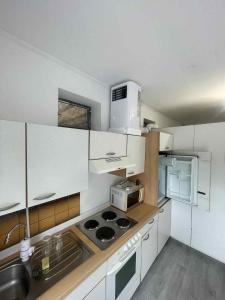 a kitchen with white cabinets and a stove top oven at SióSpot in Siófok