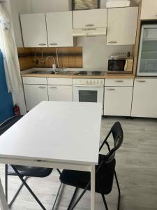 a kitchen with a white table and two chairs at SióSpot in Siófok +2 photos